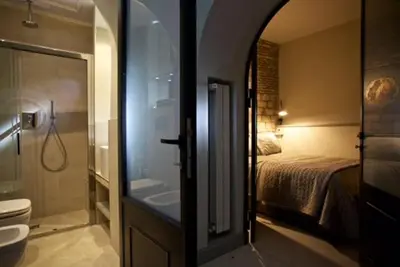 a bathroom with a shower and a toilet and a bed at Vatican design loft in Rome