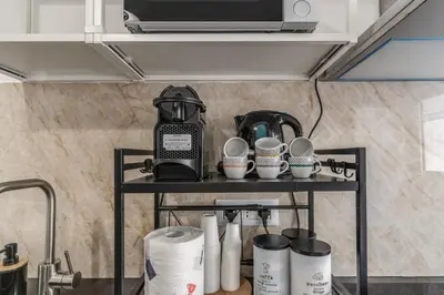 a shelf with cups and a coffee maker on it at Albadoro Apartment in Rome