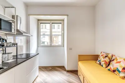 a living room with a yellow couch in a kitchen at Albadoro Apartment in Rome