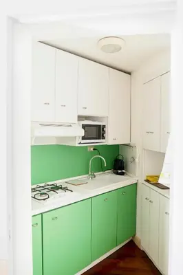 a green and white kitchen with white cabinets at Caesarina Roma, Luxury apartment in Rome