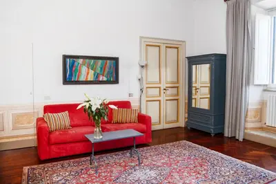 a living room with a red couch and a table at Caesarina Roma, Luxury apartment in Rome