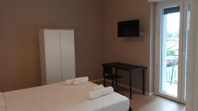 a bedroom with two beds and a table and a window at TiburtinaStay in Rome