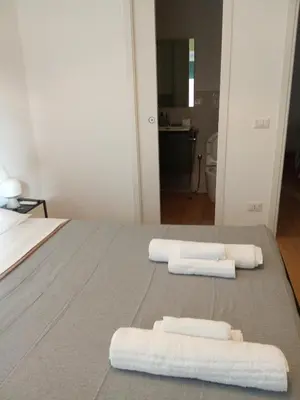 a large bed with two towels on top of it at TiburtinaStay in Rome