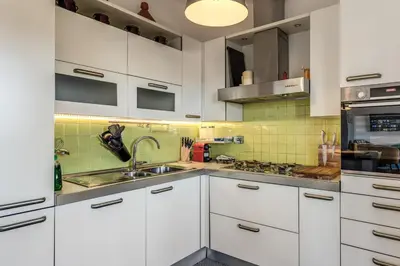 a kitchen with white cabinets and a sink at Porta maggiore 2 bedroom with terrace in Rome