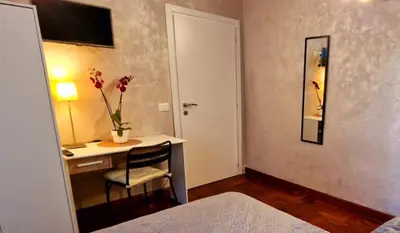 a bedroom with a bed with two paintings on the wall at Aurelio Vatican Holiday in Rome