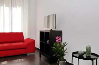 a living room with a red couch and a tv at Neo Urbis Art Aparts in Rome