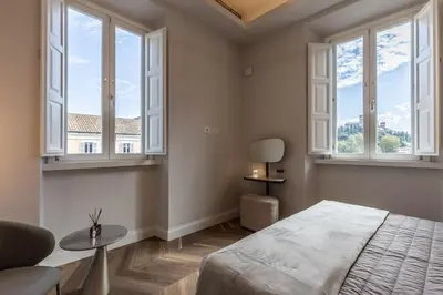 a bedroom with windows and a bed and a table at Porta Trastevere Palace in Rome