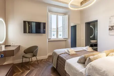 a bedroom with a bed and a desk and a chair at Porta Trastevere Palace in Rome