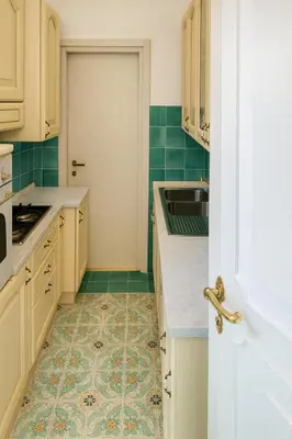 a kitchen with white cabinets and green tiles at Cola di Rienzo Attico & Charme - by 101 Flats in Rome
