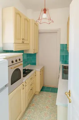 a kitchen with white cabinets and green tile floors at Cola di Rienzo Attico & Charme - by 101 Flats in Rome