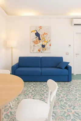a living room with a blue couch and a table at Cola di Rienzo Attico & Charme - by 101 Flats in Rome