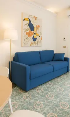 a blue couch in a living room with a table at Cola di Rienzo Attico & Charme - by 101 Flats in Rome