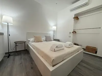 a white bedroom with a bed with two towels on it at Casa di Mara by Valentina's Dream in Rome