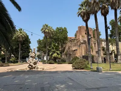a park with palm trees and a fountain in front of a castle at Casa di Mara by Valentina's Dream in Rome