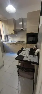 a kitchen with a table and chairs in a room at Alessandro's Home in Rome