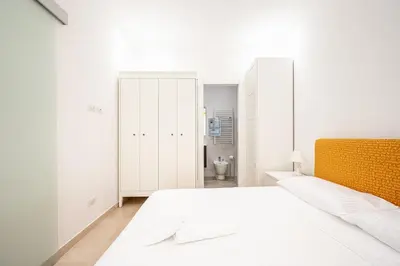 a white bedroom with a large bed and a closet at Il Pianoforte di Teresa - appartamento a Monteverde in Rome