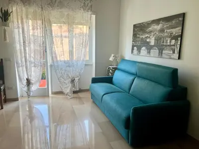 a living room with a blue couch in front of a window at Il Pianoforte di Teresa - appartamento a Monteverde in Rome