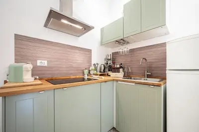 a kitchen with green cabinets and a white refrigerator at Il Pianoforte di Teresa - appartamento a Monteverde in Rome