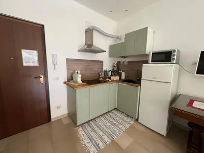 a kitchen with green cabinets and a white refrigerator at Il Pianoforte di Teresa - appartamento a Monteverde in Rome