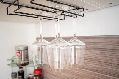 four wine glasses hanging from a rack in a kitchen at Il Pianoforte di Teresa - appartamento a Monteverde in Rome