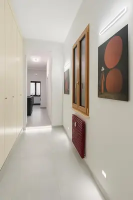 a hallway with white walls and paintings on the wall at Casa Chanel in Rome