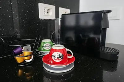 a black counter top with a red coffee cup on it at Casa Chanel in Rome