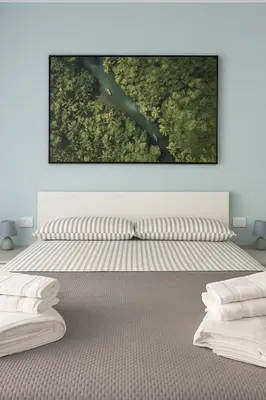 a bedroom with a bed with a painting on the wall at Casa Chanel in Rome