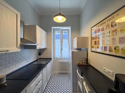 a kitchen with black counter tops and a refrigerator at Wine Stay, relaxation and style in Rome in Rome