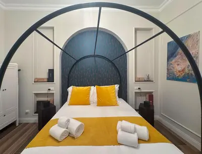a bedroom with a large bed with two yellow pillows at Wine Stay, relaxation and style in Rome in Rome