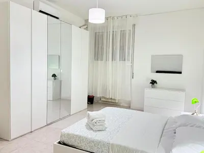 a white bedroom with a bed and a mirror at Always Home in Rome