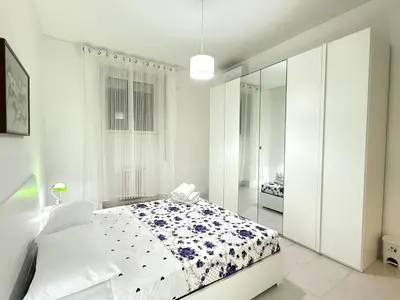 a white bedroom with a bed and a mirror at Always Home in Rome