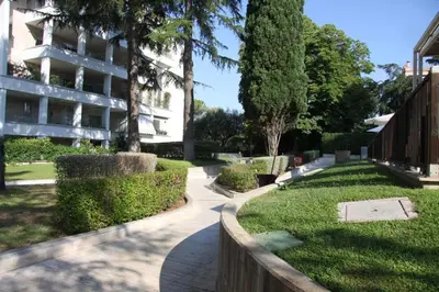 a walkway in a park next to a building at Clio Apartment in Rome