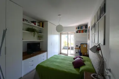 a bedroom with a green bed and a television at Clio Apartment in Rome