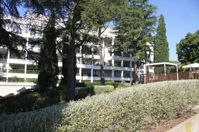 a white building with trees in front of it at Clio Apartment in Rome