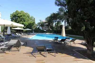 a swimming pool with chairs and umbrellas next to at Clio Apartment in Rome