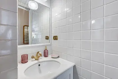 a white bathroom with a sink and a mirror at Trastevere Liberty House in Rome