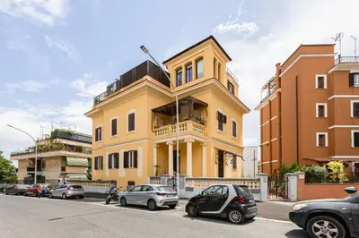 a yellow building with cars parked in front of it at Trastevere Liberty House in Rome
