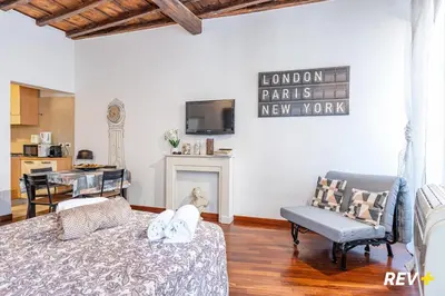 a living room with a bed and a chair and a tv at Banchi Nuovi Apartment in Rome