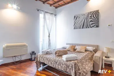 a bedroom with a bed and a television and a window at Banchi Nuovi Apartment in Rome