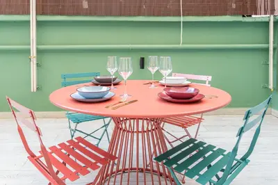 a red table with four chairs and wine glasses at Vatican Museums Apartment with Romantic Terrace in Rome