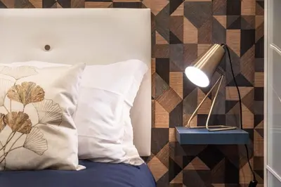 a bed with a white pillow and a lamp at Vatican Museums Apartment with Romantic Terrace in Rome