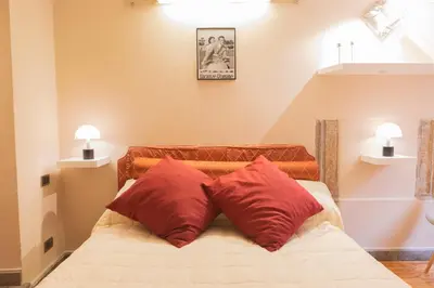 a bedroom with two red pillows on a bed at La Dolce Vita Pantheon Suite in Rome