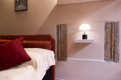 a bedroom with a bed and a lamp on a wall at La Dolce Vita Pantheon Suite in Rome