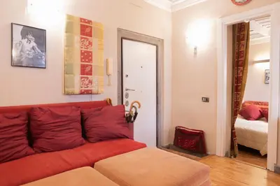 a living room with a red couch and a bedroom at La Dolce Vita Pantheon Suite in Rome