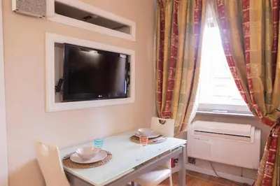 a small dining room with a white table and a television at La Dolce Vita Pantheon Suite in Rome