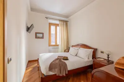 a bedroom with a bed with white sheets and a window at iFlat Vintage Retreat - Comfort in Central Rome in Rome