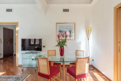 a dining room with a table with a vase of flowers at iFlat Vintage Retreat - Comfort in Central Rome in Rome