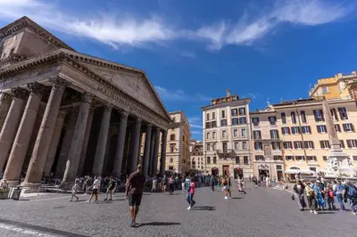 a group of people walking in a city square at Madonna del Pantheon in Rome