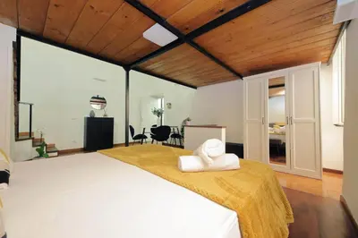 a bedroom with a large bed with a wooden ceiling at Maison Florienne in Rome