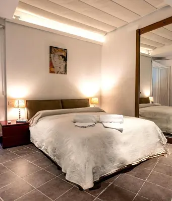 a bedroom with a large bed and a mirror at Callimaco Domus in Rome